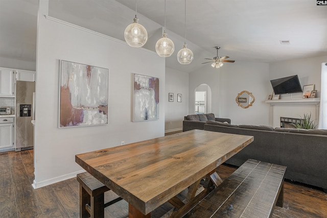dining room with ceiling fan, dark hardwood / wood-style floors, and vaulted ceiling