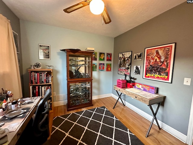 home office with ceiling fan and light hardwood / wood-style flooring