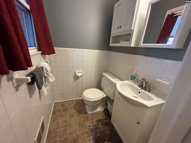 bathroom featuring vanity, backsplash, tile walls, tile floors, and toilet