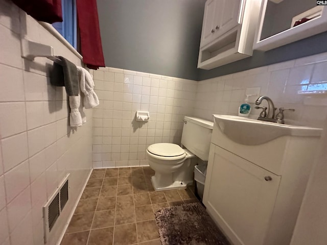 bathroom featuring tile walls, tile floors, toilet, tasteful backsplash, and large vanity