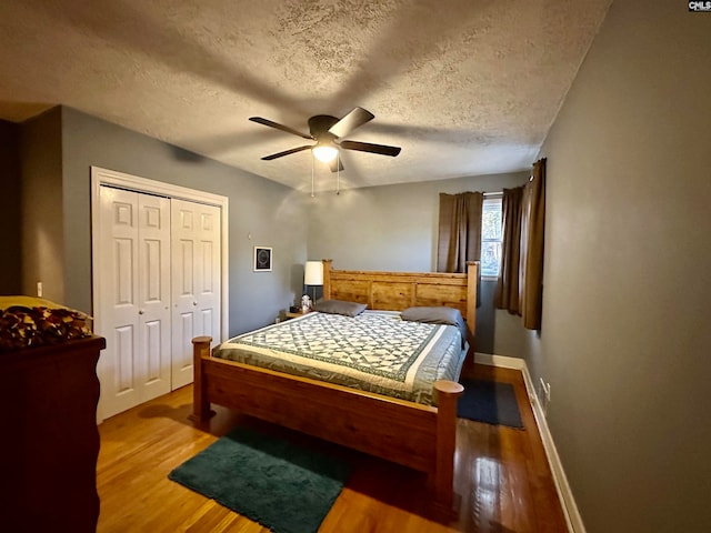 bedroom with a closet, a textured ceiling, ceiling fan, and light hardwood / wood-style flooring