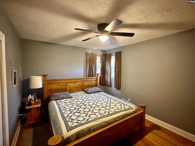 bedroom with ceiling fan and dark hardwood / wood-style flooring