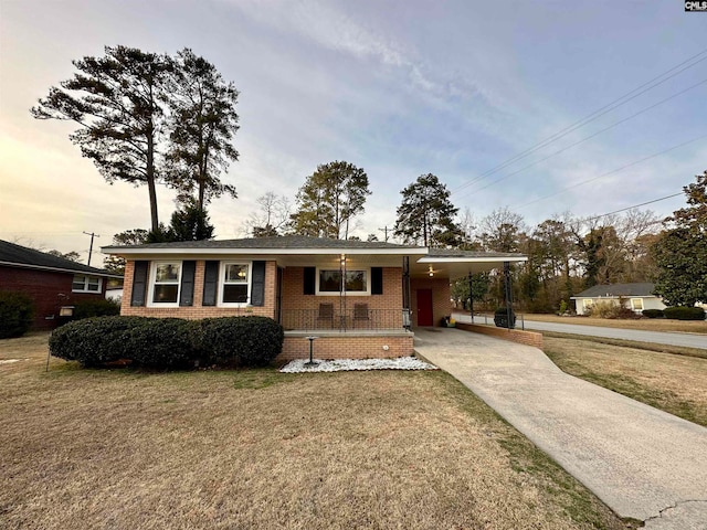 ranch-style house featuring a carport and a front yard