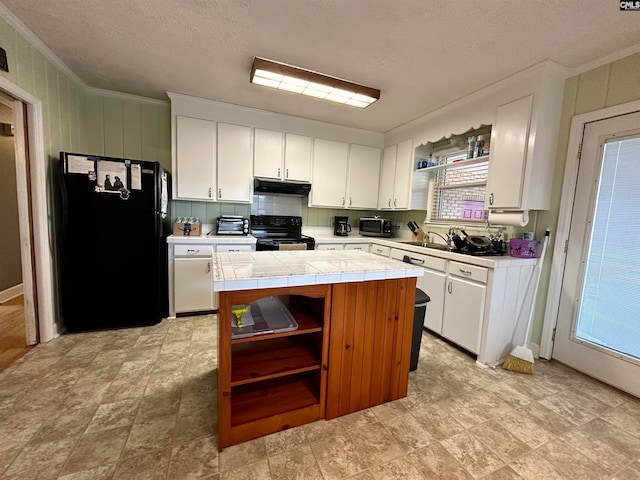 kitchen featuring tile counters, crown molding, white cabinets, light tile flooring, and black appliances