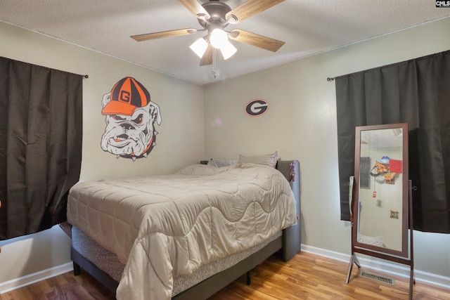 bedroom featuring ceiling fan, light wood-type flooring, and a textured ceiling