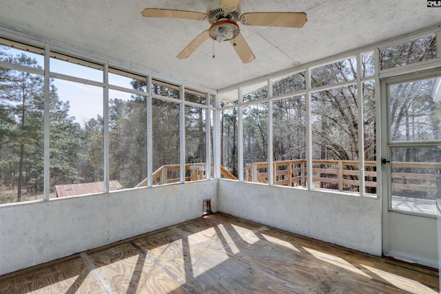 unfurnished sunroom featuring ceiling fan