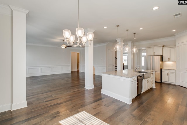 kitchen featuring decorative light fixtures, stainless steel appliances, a center island with sink, light stone counters, and dark hardwood / wood-style flooring