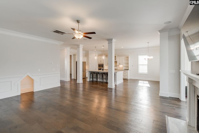 unfurnished living room with crown molding, dark hardwood / wood-style floors, and ceiling fan with notable chandelier