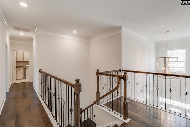 hall featuring dark hardwood / wood-style flooring, an inviting chandelier, and crown molding