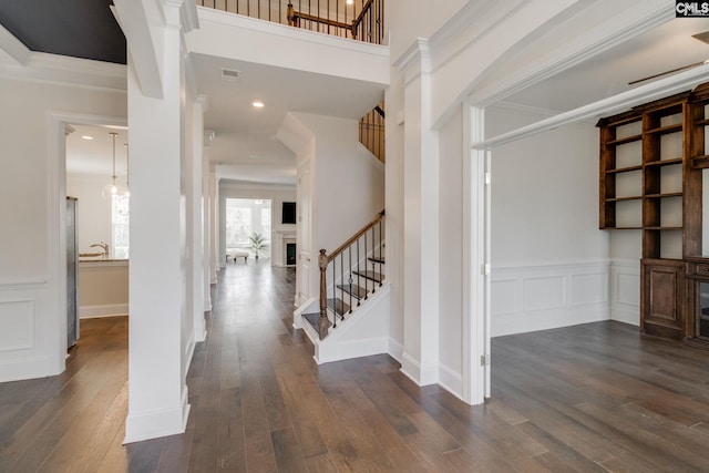 entrance foyer featuring ornamental molding and dark hardwood / wood-style flooring