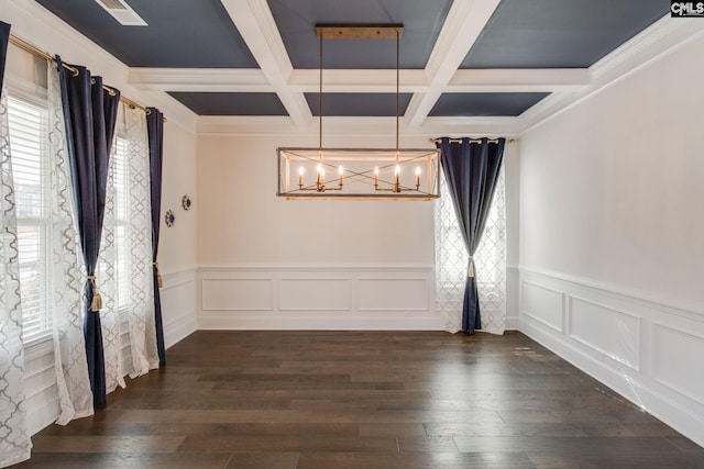 unfurnished room with coffered ceiling, dark wood-type flooring, an inviting chandelier, beam ceiling, and ornamental molding