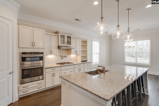 kitchen with light stone countertops, tasteful backsplash, double oven, and sink