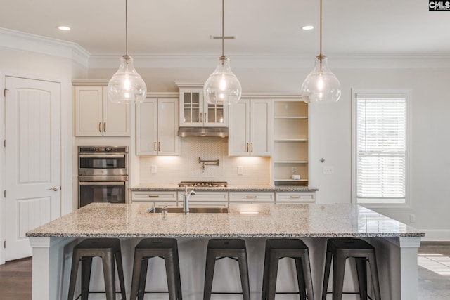 kitchen with stainless steel appliances, pendant lighting, a breakfast bar, and sink