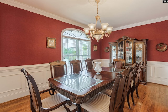 dining room with a chandelier, crown molding, and light hardwood / wood-style flooring