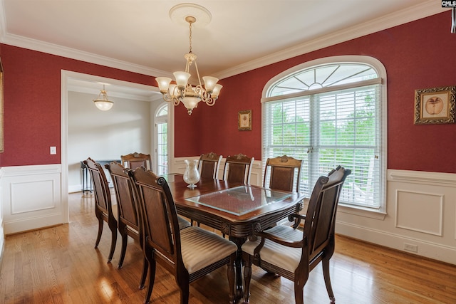 dining space with a chandelier, a healthy amount of sunlight, light hardwood / wood-style floors, and crown molding