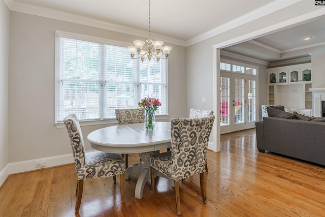 dining space with a chandelier, light hardwood / wood-style floors, french doors, and ornamental molding