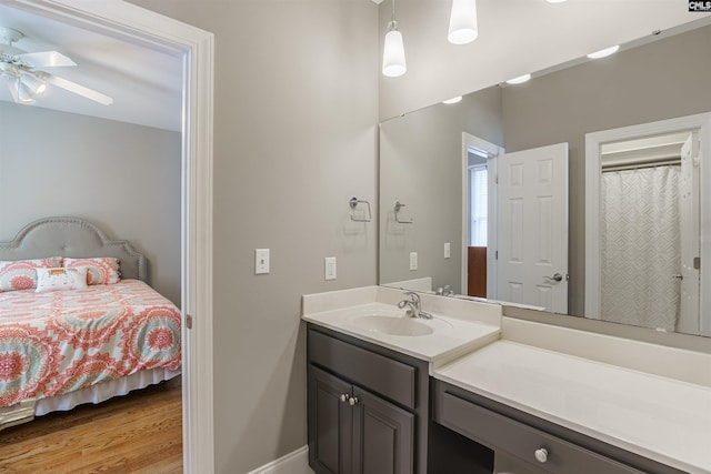 bathroom with wood-type flooring, ceiling fan, and large vanity