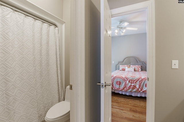 bathroom featuring toilet, wood-type flooring, and ceiling fan