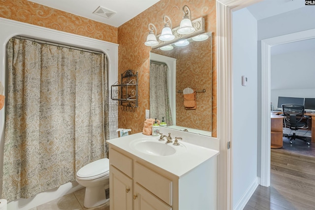 bathroom with toilet, large vanity, and hardwood / wood-style flooring