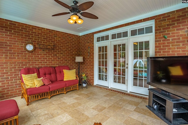 sunroom featuring ceiling fan and french doors