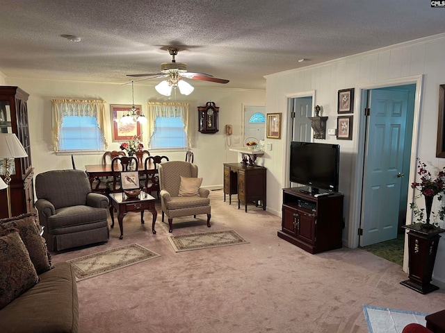 carpeted living room featuring a textured ceiling, ceiling fan with notable chandelier, and ornamental molding