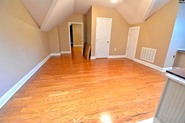 bonus room with vaulted ceiling and light hardwood / wood-style floors