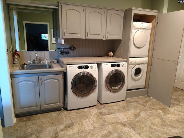 laundry area with sink, light tile flooring, cabinets, and washing machine and clothes dryer