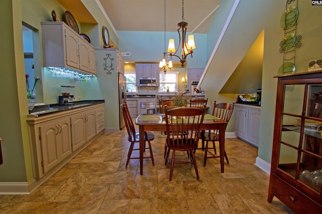 tiled dining space featuring a notable chandelier