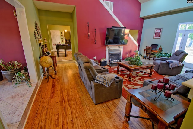 living room featuring a towering ceiling and light hardwood / wood-style floors