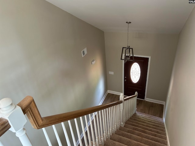 staircase with lofted ceiling and hardwood / wood-style floors