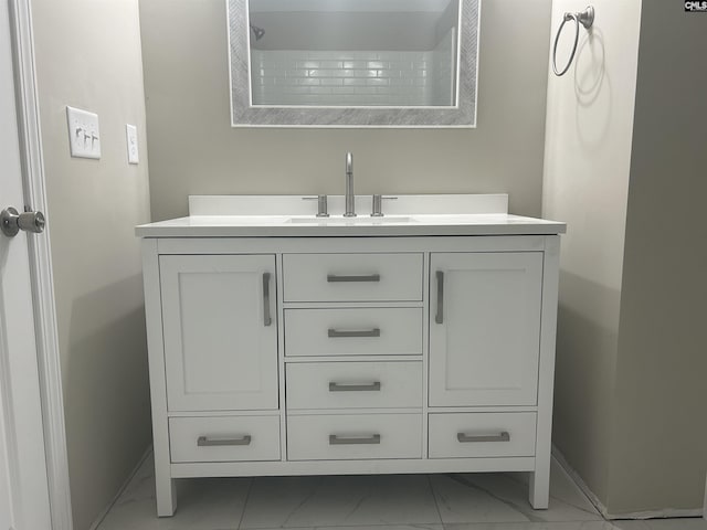 bathroom with marble finish floor, baseboards, and vanity