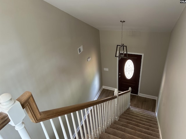 stairway featuring visible vents, baseboards, and wood finished floors