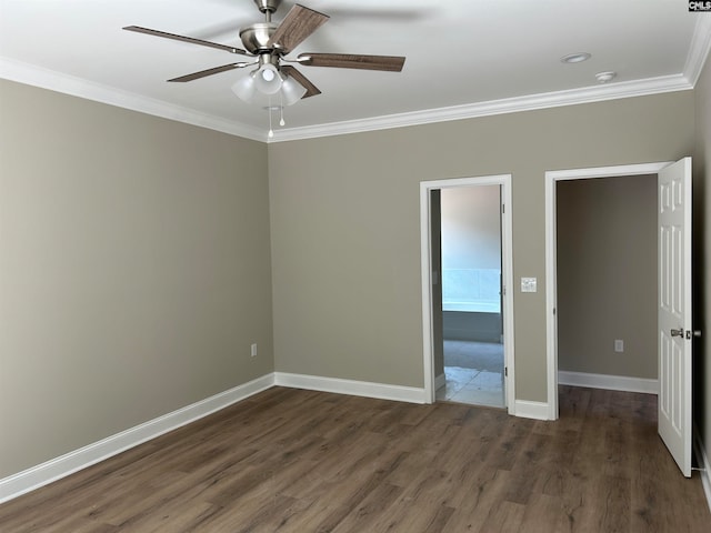 interior space with baseboards, dark wood finished floors, a ceiling fan, and crown molding