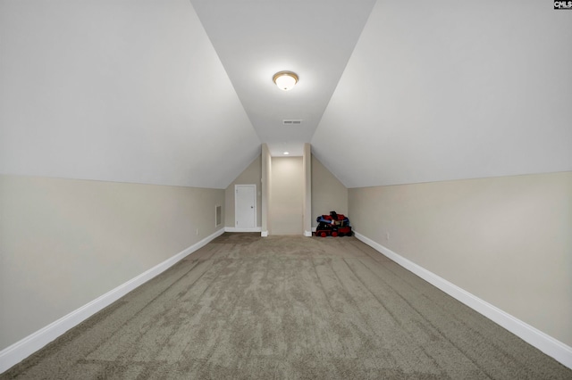 additional living space featuring lofted ceiling and carpet flooring