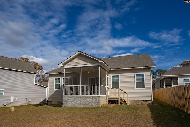 rear view of property with a sunroom and a lawn