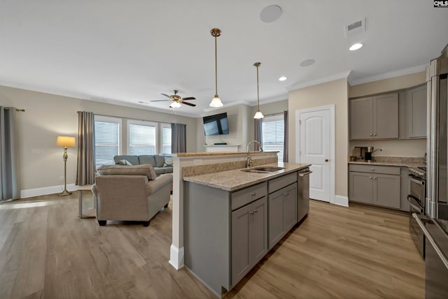 kitchen with light hardwood / wood-style flooring, ceiling fan, sink, appliances with stainless steel finishes, and pendant lighting