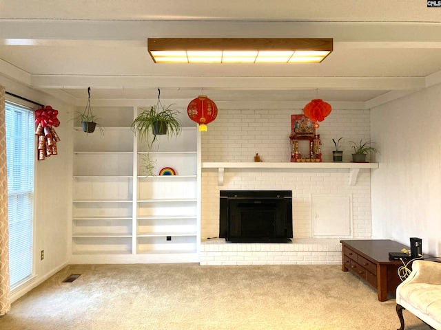 unfurnished living room featuring light carpet, a brick fireplace, and built in shelves