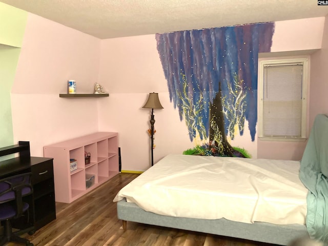 bedroom with dark hardwood / wood-style floors and a textured ceiling