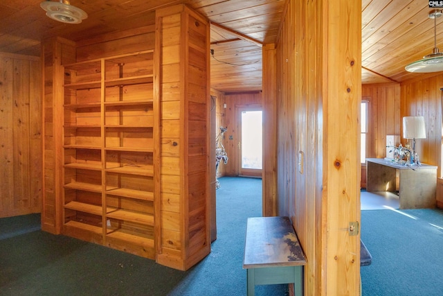 hallway featuring wooden ceiling, carpet flooring, and wood walls