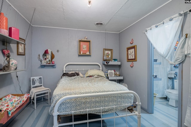 bedroom featuring a textured ceiling and ensuite bath