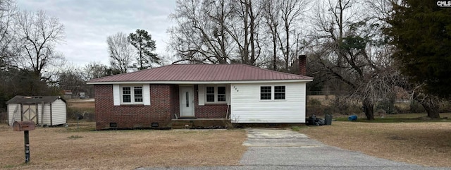 view of front of property featuring a storage shed