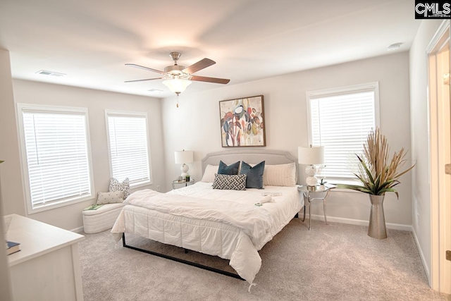 carpeted bedroom featuring ceiling fan and multiple windows