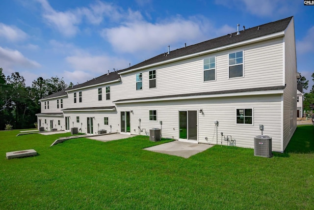 back of property with cooling unit, a patio area, and a lawn