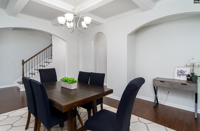 dining space featuring hardwood / wood-style floors, ornamental molding, beamed ceiling, coffered ceiling, and an inviting chandelier