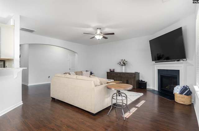 living room featuring ceiling fan and dark hardwood / wood-style floors