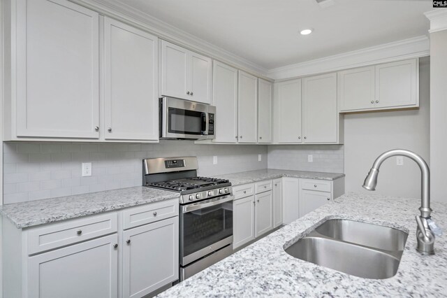 kitchen featuring white cabinets, decorative backsplash, sink, and appliances with stainless steel finishes