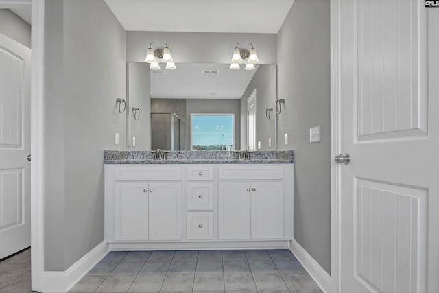 bathroom featuring a chandelier, tile patterned flooring, vanity, and a shower with shower door