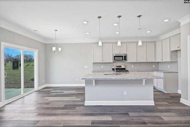 kitchen with pendant lighting, sink, an island with sink, light stone counters, and stainless steel appliances