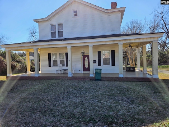 farmhouse with covered porch, a front yard, and ceiling fan