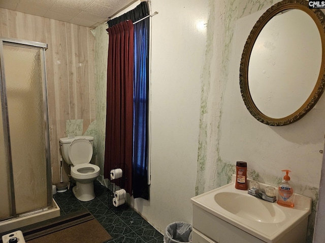 bathroom featuring toilet, tile floors, a shower with shower door, and vanity